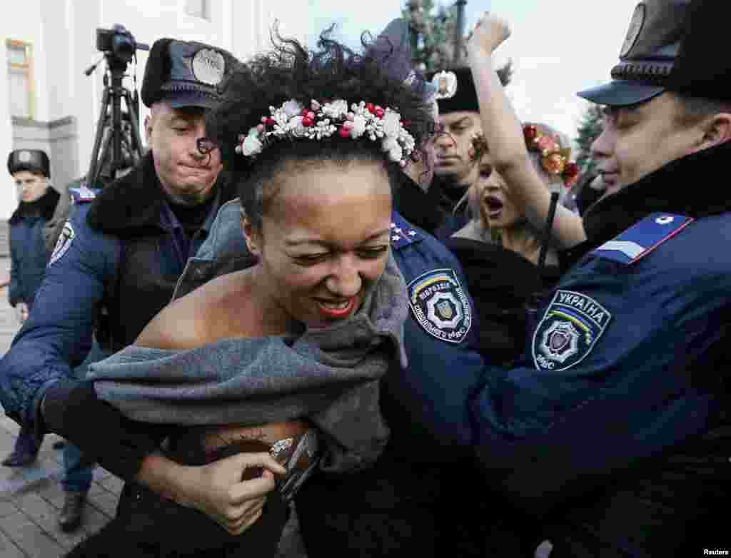 Киевалда полициялъ ккурай &nbsp;Femen къукъаялъул гIахьалчIужу. Гьаб нухалда гьел рахъун рукIана гьомофобиялде данде протест лъазабизе. 12Ноя2015 &nbsp;(Reuters/Gleb Garanich)