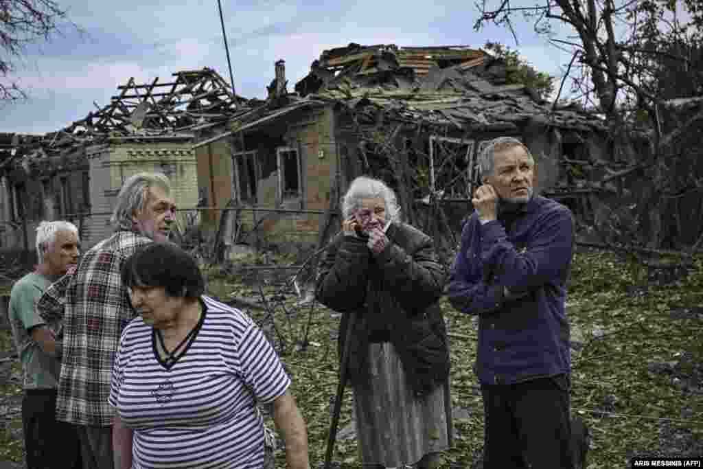 Местные жители собрались на улице после того, как в результате ракетного удара погибла пожилая женщина &nbsp;