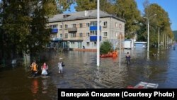 Спасатели выводят жителей с затопленной улицы