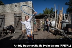 6-летняя Тома играет во дворе дома, откуда виден Донецк. В нескольких сотнях метров прошла линия фронта