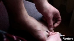 Russia -- A drug user injects heroin in the town of Tver, October 3, 2010