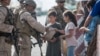 AFGHANISTAN -- A Marine with Special Purpose Marine Air-Ground Task Force-Crisis Response-Central Command (SPMAGTF-CR-CC) opens a meal ready-to-eat for the children to eat during an evacuation at Hamid Karzai International Airport in Kabul, August 21, 202